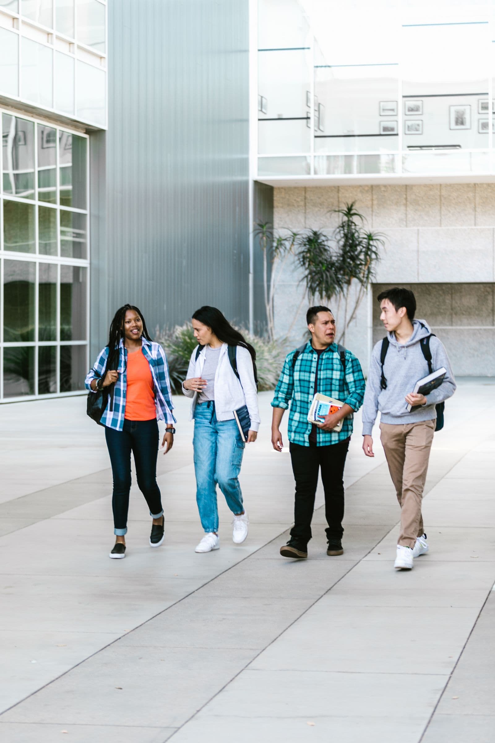 Students walking across a university campus with their books