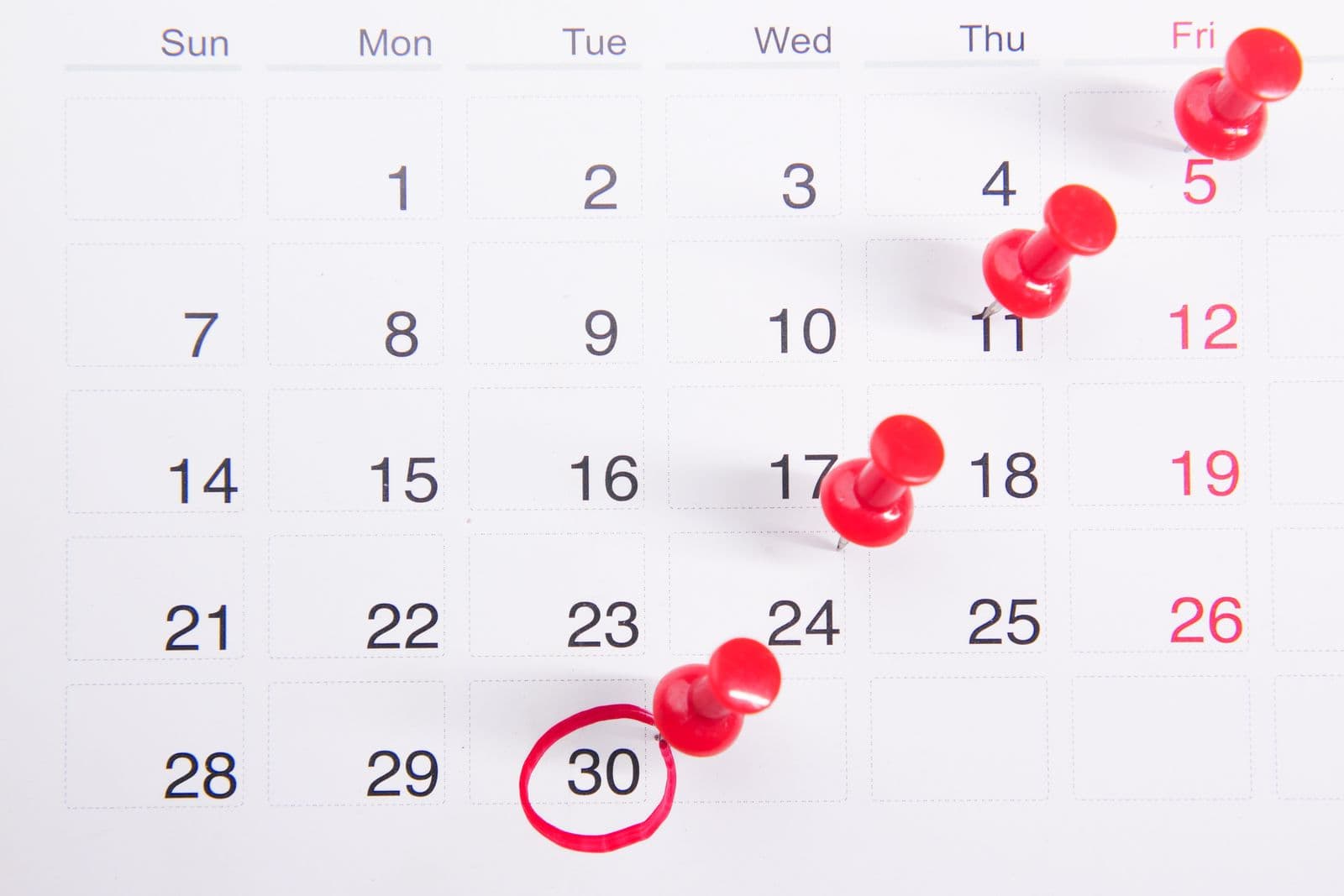 A calendar with pinned dates and one circled in red