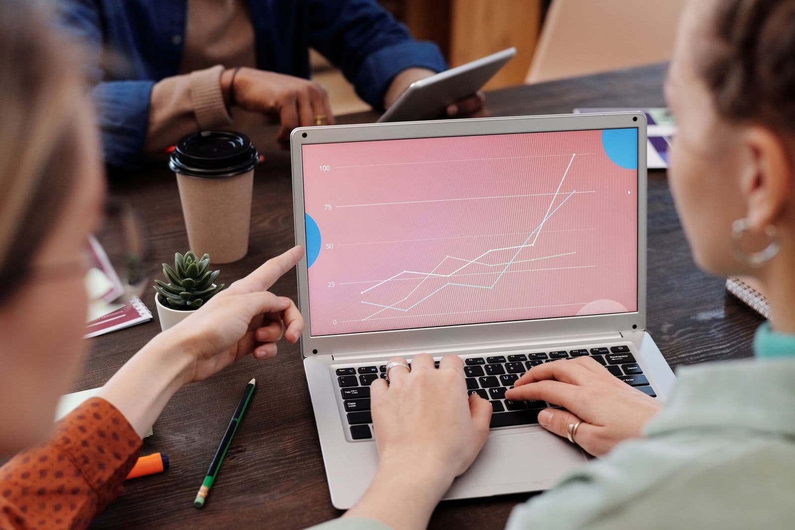 A team looking at a rising chart on a laptop