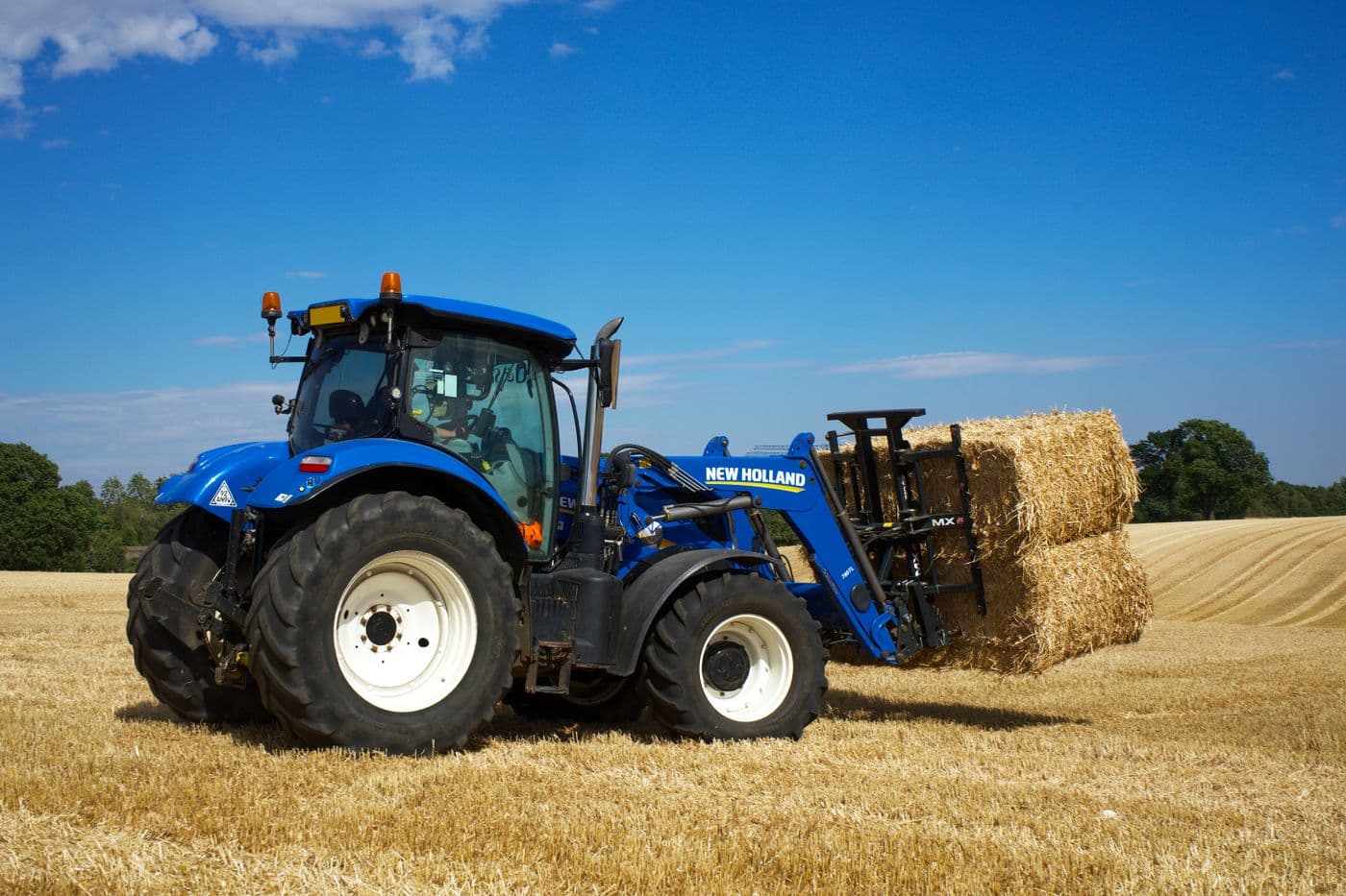 A tractor baling hay in a UK field