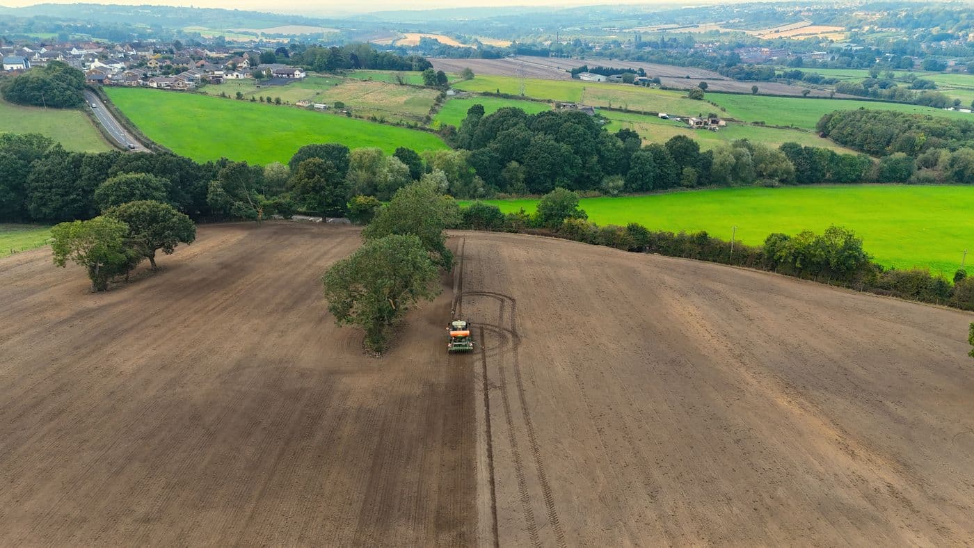 A tractor preparing fields in the English countryside, from above