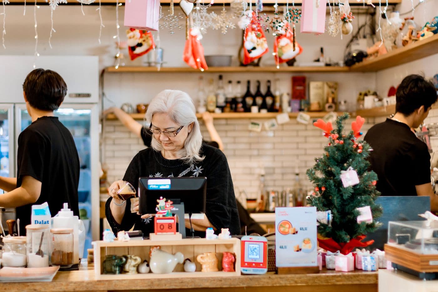 An older woman serving at a café counter