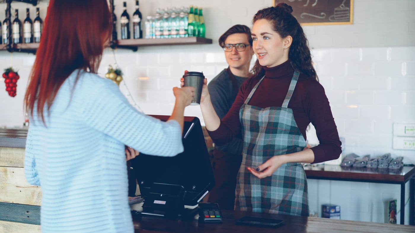 A barista serving a customer in a café