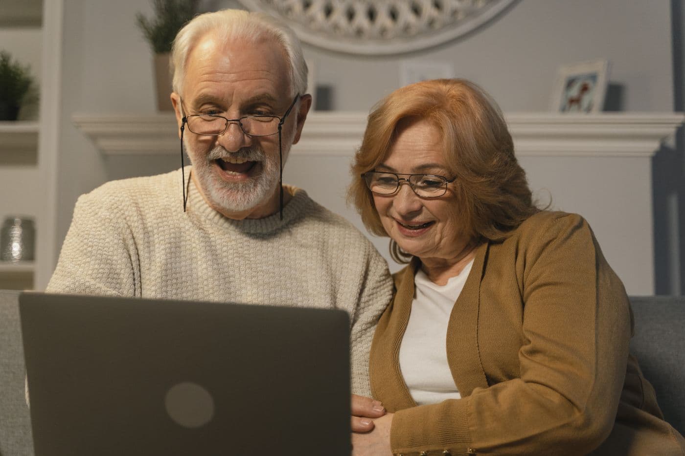 An older couple on a video call on their laptop
