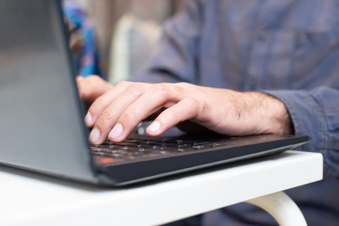 Hands typing on a laptop keyboard