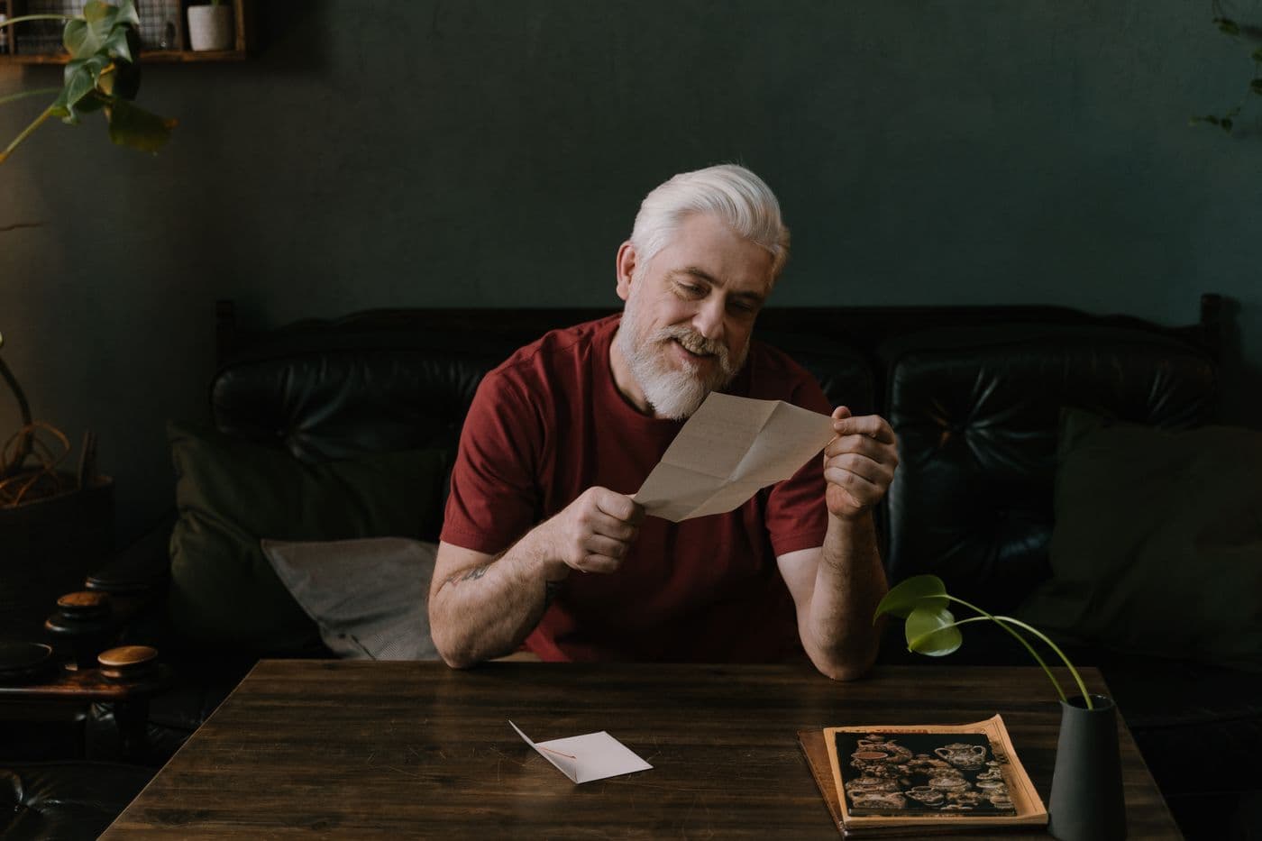 An older man reading a letter at home