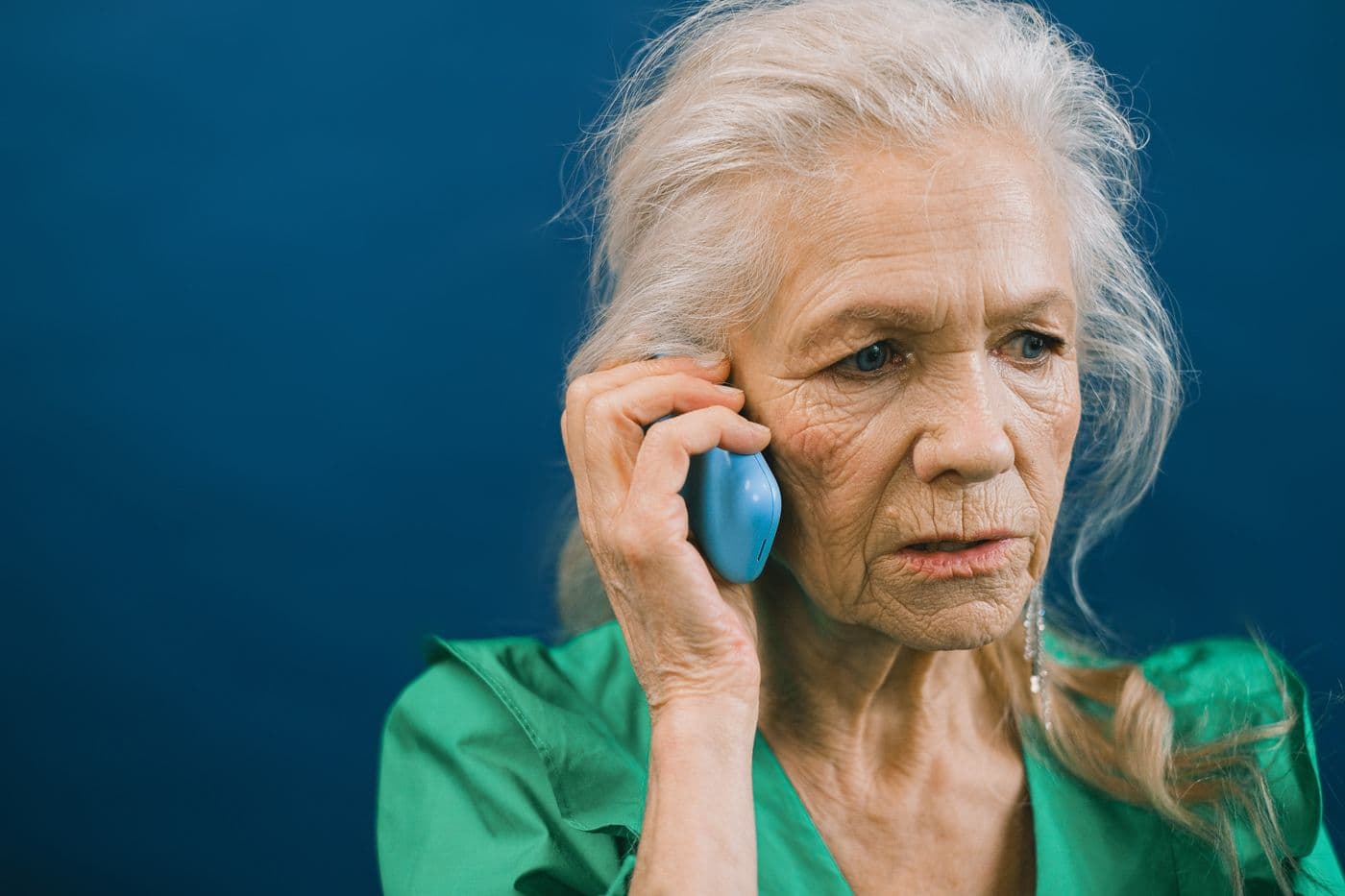 An older woman on the phone, looking worried