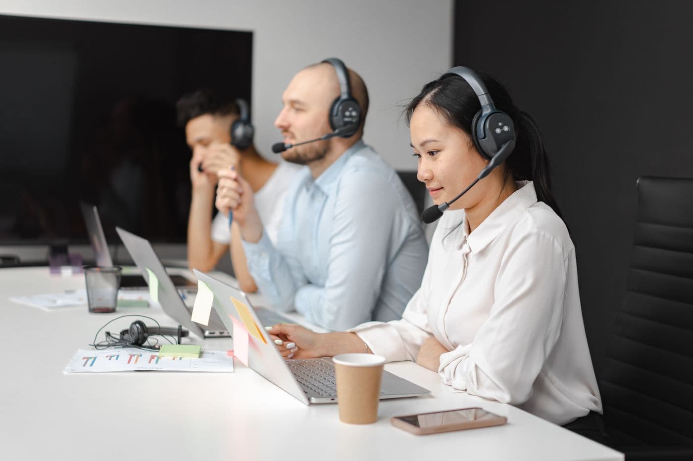 Contact centre agents wearing headsets working on laptops