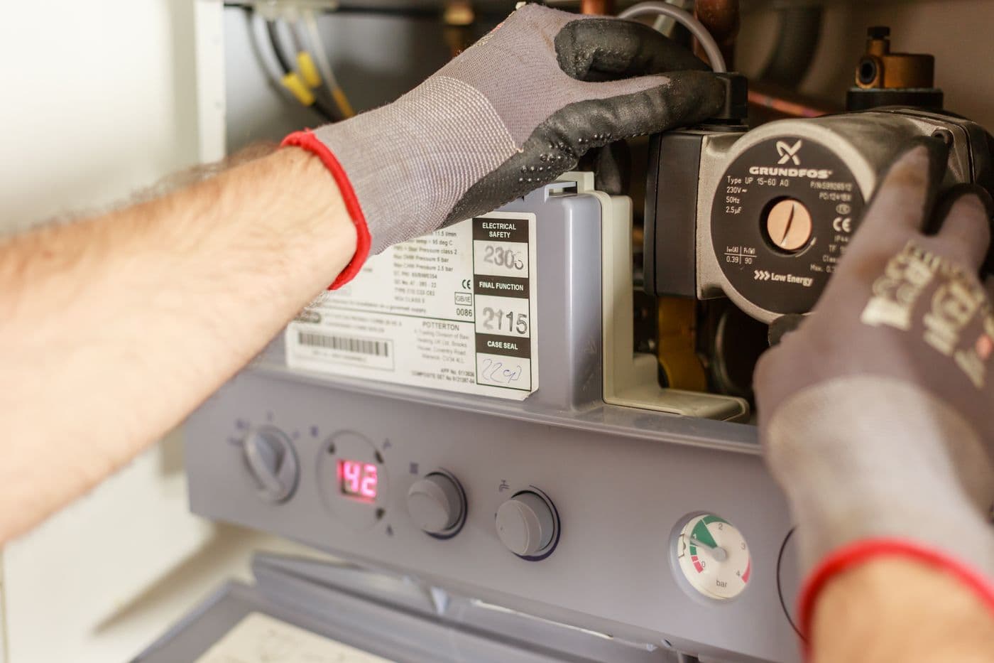 An engineer adjusting a boiler at home