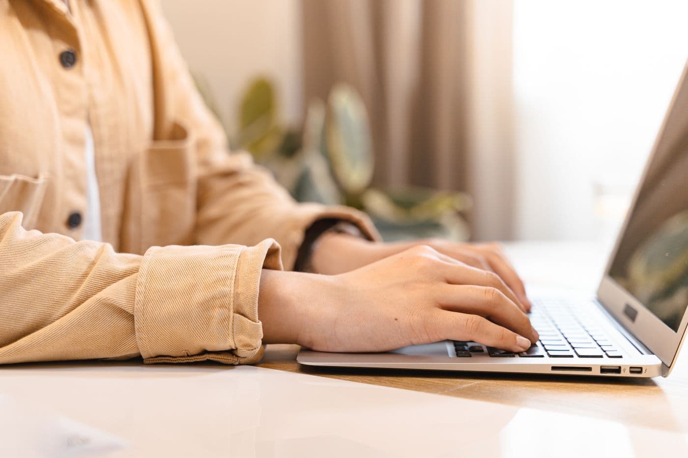 Someone typing on a laptop at home